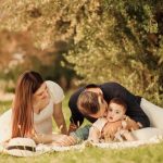A happy family having a picnic in a lush green park setting during the day.
